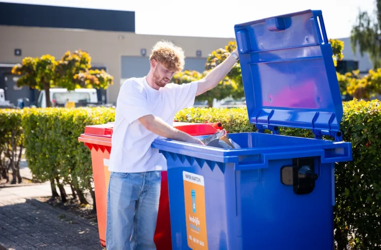 Papierafval wordt weggegooid in een blauwe papier en kartoncontainer
